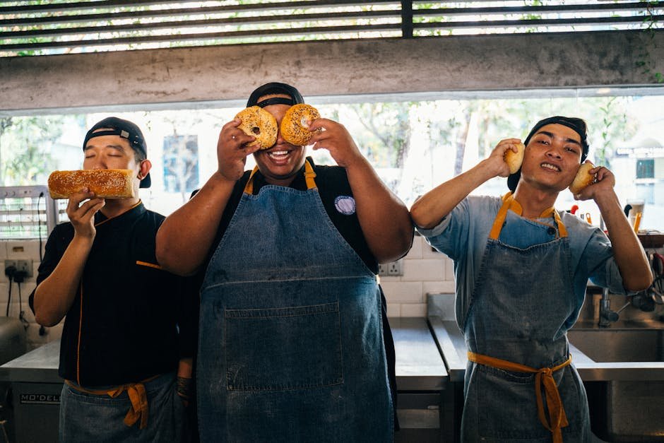 Chefs having fun with bread and bagels in a bright kitchen setting.